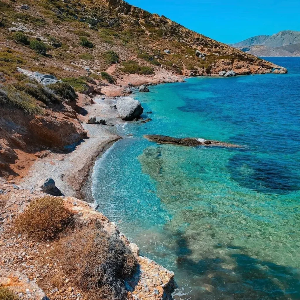 Hidden beach with crystal clear turquoise waters and rocky coastline on Telendos Island Greece