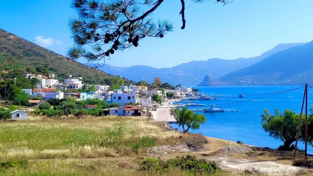 Panoramic coastal view of Telendos Island with traditional white houses, harbor, and Aegean Sea