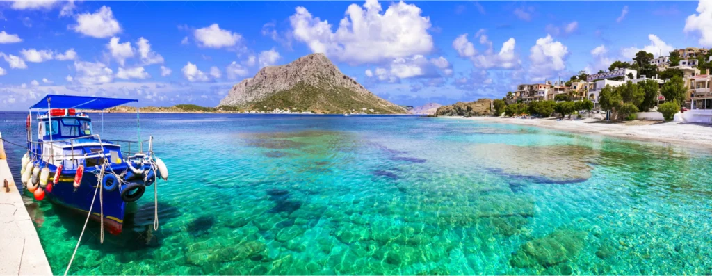 Traditional fishing boat in crystal clear turquoise waters on Telendos Island Greece